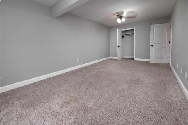 unfurnished bedroom with carpet floors, beamed ceiling, a closet, ceiling fan, and baseboards
