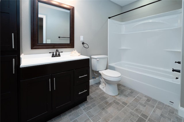 full bathroom featuring toilet, shower / bath combination, vanity, and baseboards