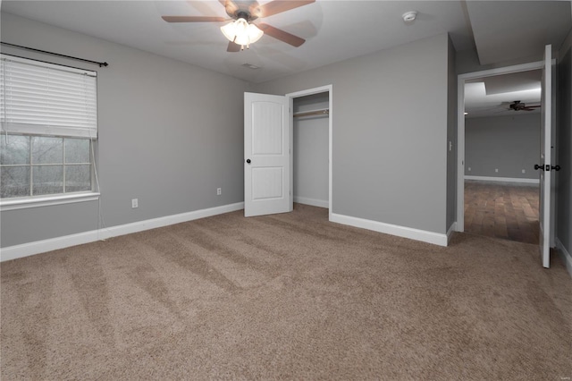 unfurnished bedroom with a closet, carpet flooring, a ceiling fan, and baseboards