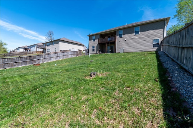 rear view of house featuring fence and a yard