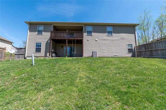 rear view of house with a lawn and fence