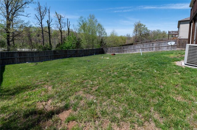view of yard with central AC and a fenced backyard