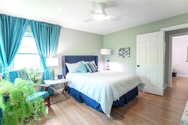 bedroom with a ceiling fan, baseboards, and wood finished floors