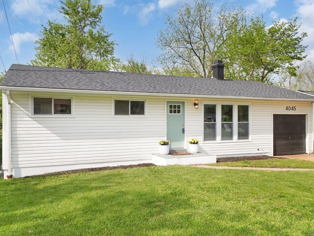 ranch-style home featuring an attached garage, a chimney, a shingled roof, and a front lawn