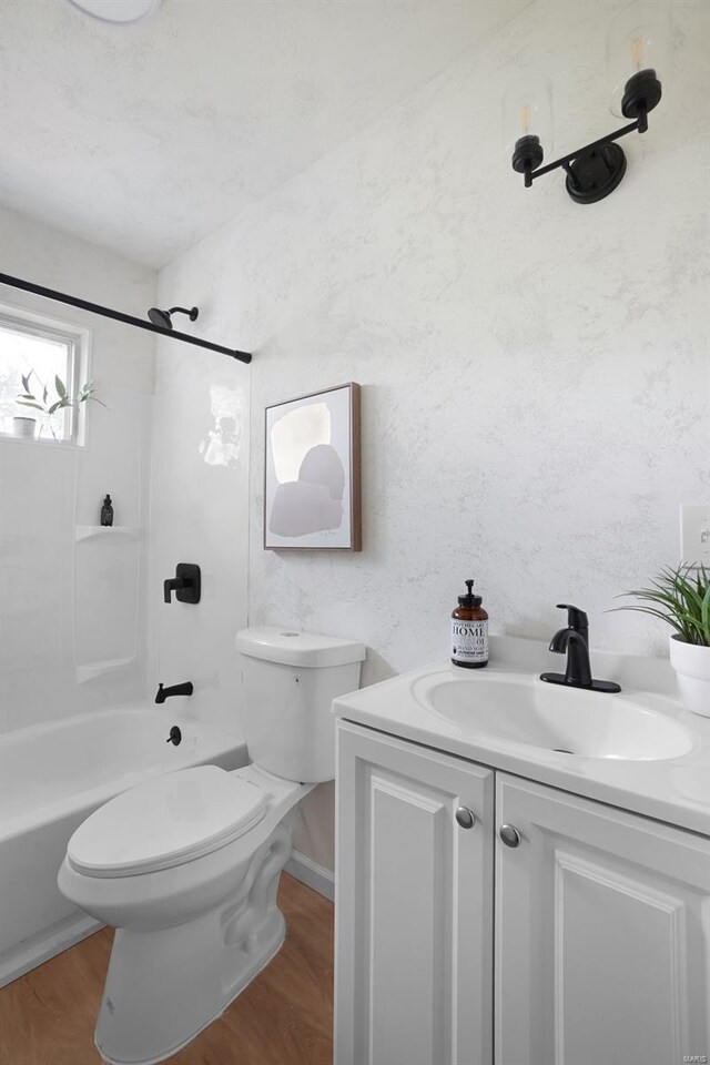 full bathroom featuring toilet, tub / shower combination, wood finished floors, and vanity