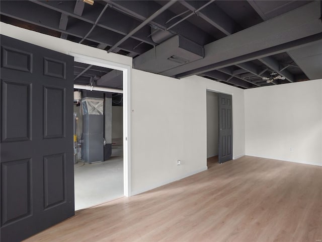 finished below grade area featuring heating unit and wood finished floors