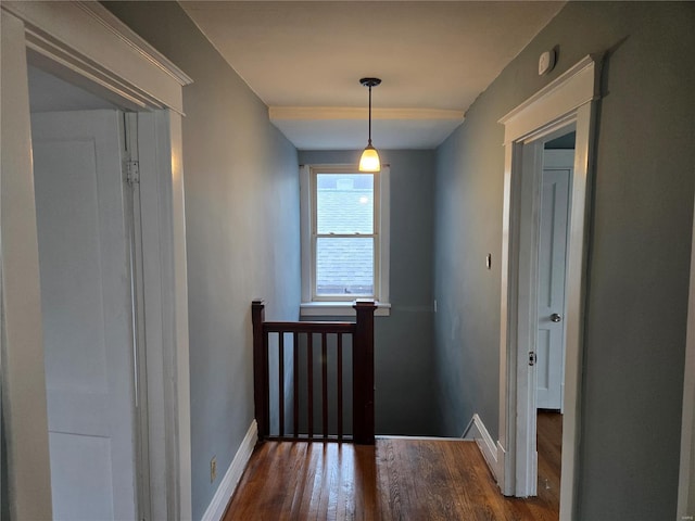 hall with an upstairs landing, dark wood-style flooring, and baseboards