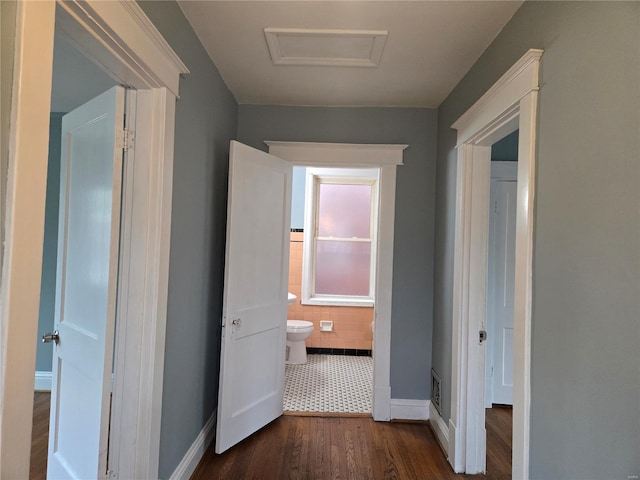 hall featuring attic access, dark wood finished floors, and baseboards