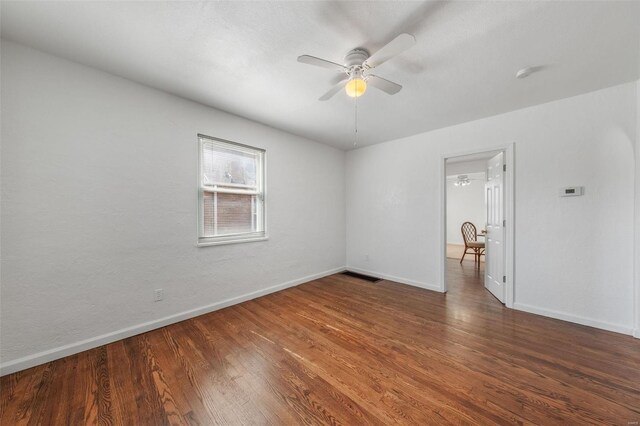 unfurnished room featuring baseboards, ceiling fan, wood finished floors, and visible vents