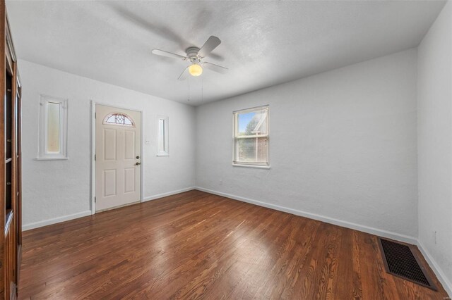 foyer featuring baseboards, ceiling fan, visible vents, and wood finished floors