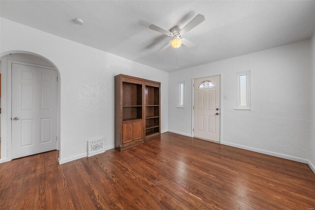 foyer entrance featuring visible vents, arched walkways, a ceiling fan, and wood finished floors