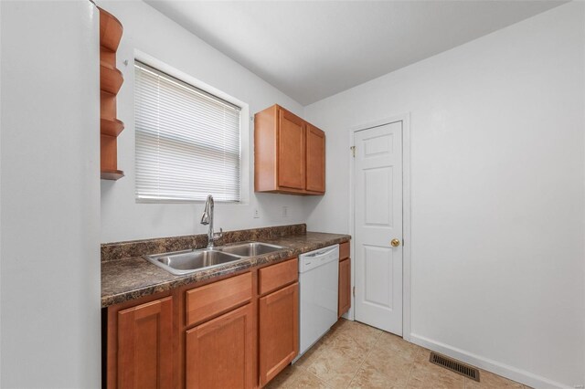 kitchen with visible vents, white dishwasher, a sink, and dark countertops