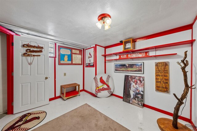 playroom featuring baseboards and finished concrete floors