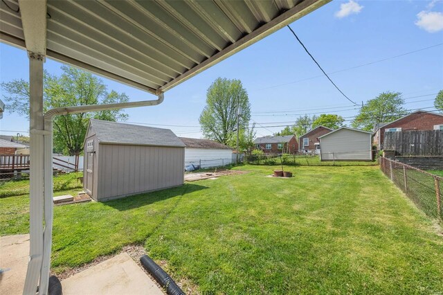 view of yard with a fenced backyard, an outbuilding, and a shed