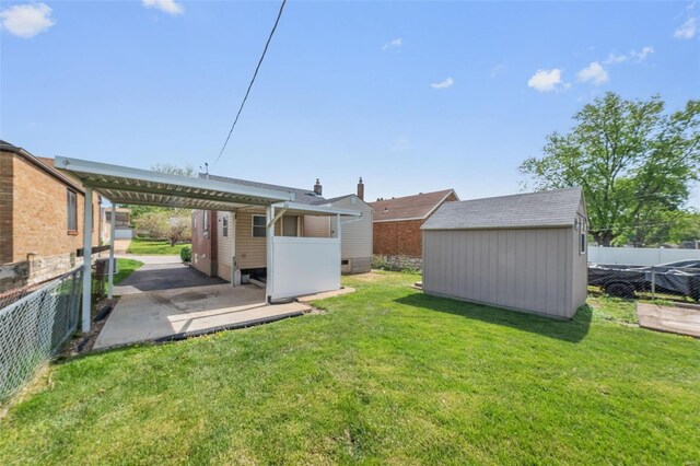 view of yard with fence, an outbuilding, and a shed