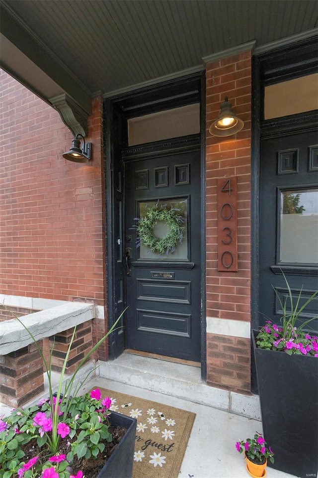 property entrance with a porch and brick siding