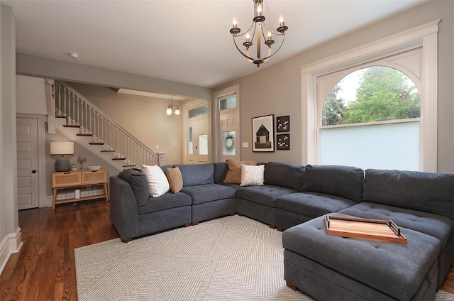 living area featuring stairs, a notable chandelier, and wood finished floors