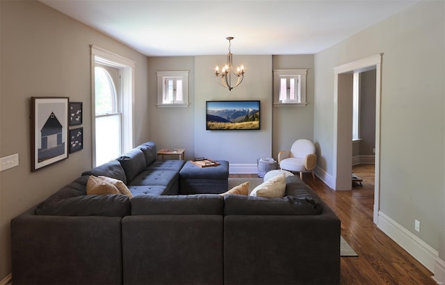 living room featuring a healthy amount of sunlight, baseboards, dark wood-style floors, and a chandelier