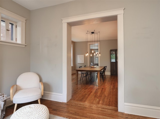 sitting room with baseboards and wood finished floors