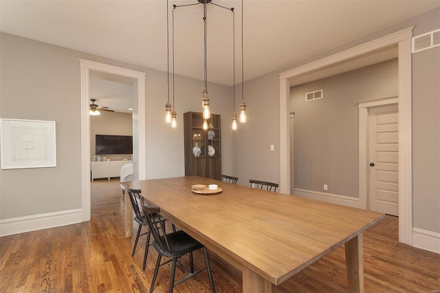 dining area with baseboards, a ceiling fan, dark wood finished floors, and visible vents