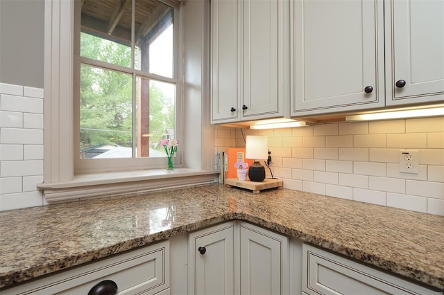 details featuring light stone counters and backsplash