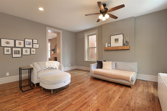 living area featuring visible vents, wood finished floors, baseboards, recessed lighting, and a ceiling fan