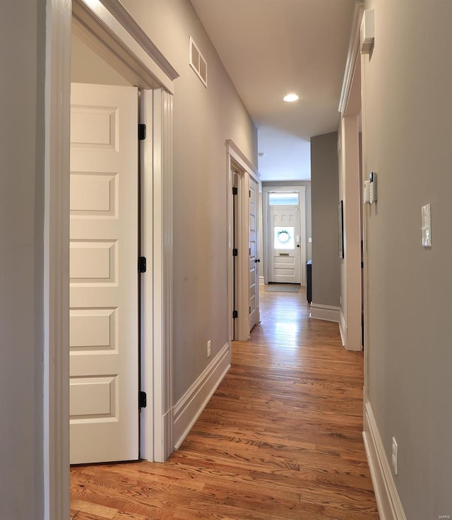 hall with recessed lighting, baseboards, visible vents, and light wood finished floors