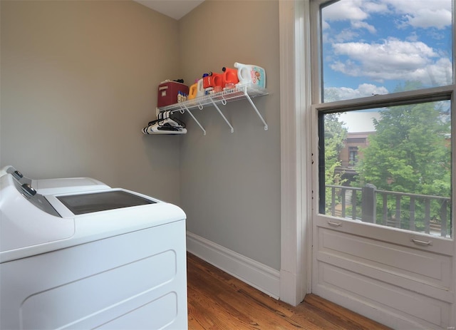 laundry room featuring baseboards, laundry area, wood finished floors, and washer and clothes dryer