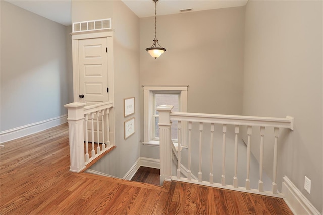 staircase featuring visible vents, baseboards, and wood finished floors