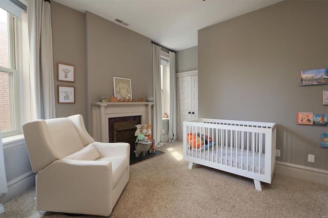bedroom featuring carpet flooring, visible vents, multiple windows, and a fireplace