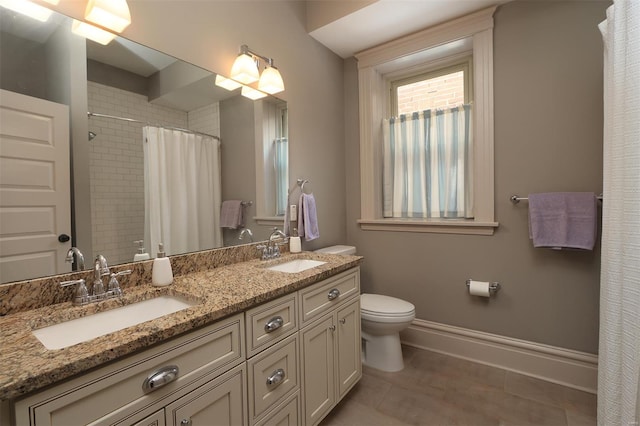 bathroom featuring tile patterned flooring, a sink, curtained shower, and toilet