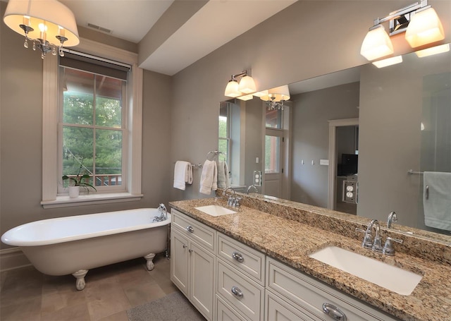 full bath with double vanity, a soaking tub, visible vents, and a sink