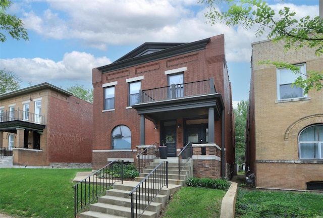 view of front facade featuring brick siding, a front lawn, a balcony, and covered porch