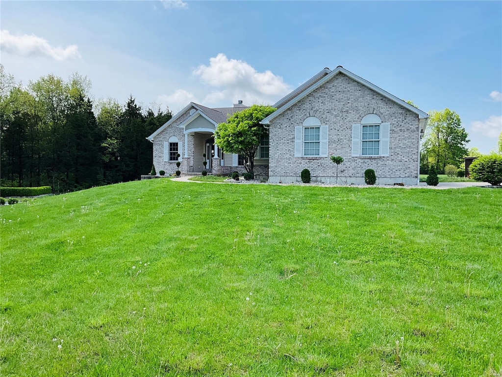 single story home with brick siding and a front yard
