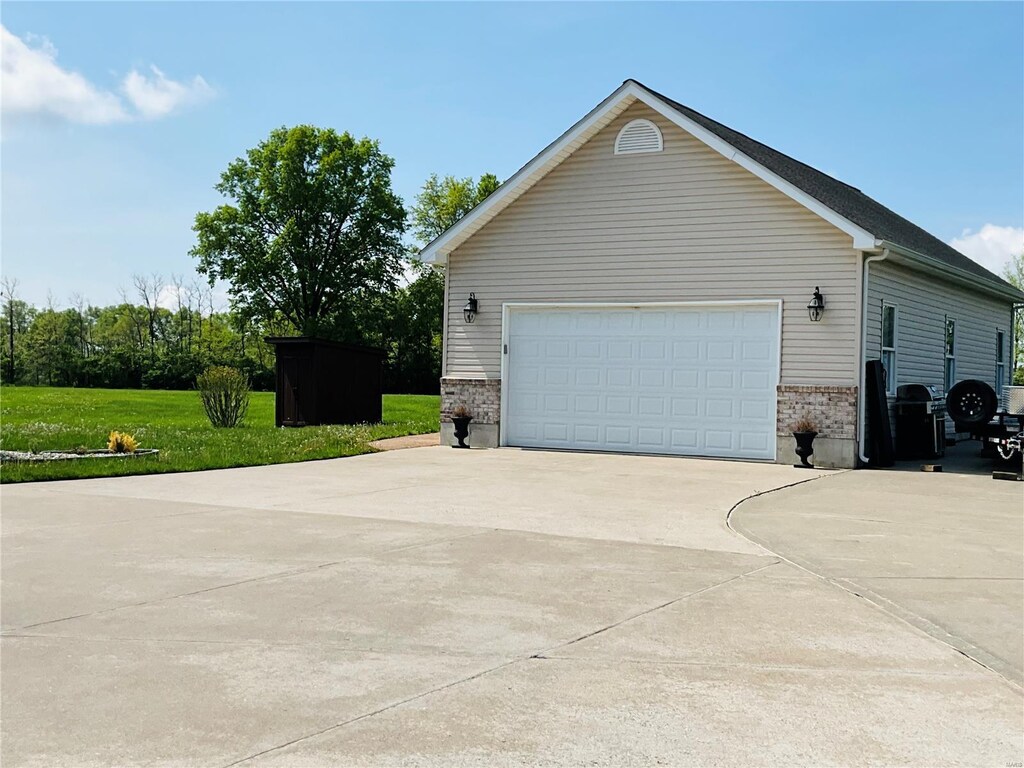 view of home's exterior featuring a lawn, driveway, and brick siding