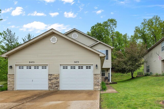 view of front of home featuring a garage, a front lawn, stone siding, and concrete driveway
