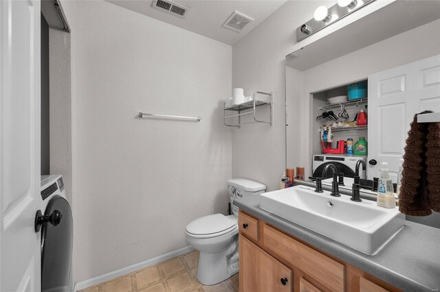 bathroom featuring vanity, baseboards, toilet, and visible vents