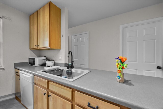kitchen featuring baseboards, a sink, and white appliances