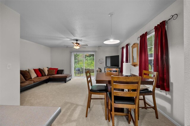 dining area featuring carpet floors, a ceiling fan, and baseboards