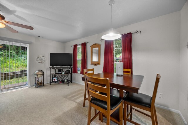 dining area featuring a ceiling fan, baseboards, light colored carpet, and visible vents