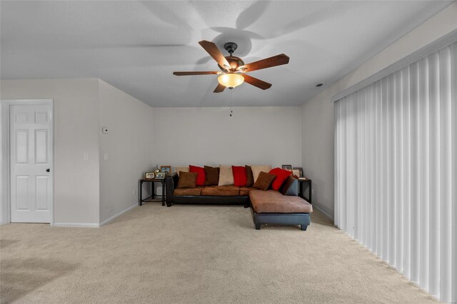 carpeted living room with baseboards and a ceiling fan