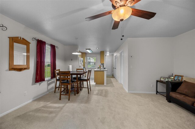dining space with baseboards, light carpet, and ceiling fan