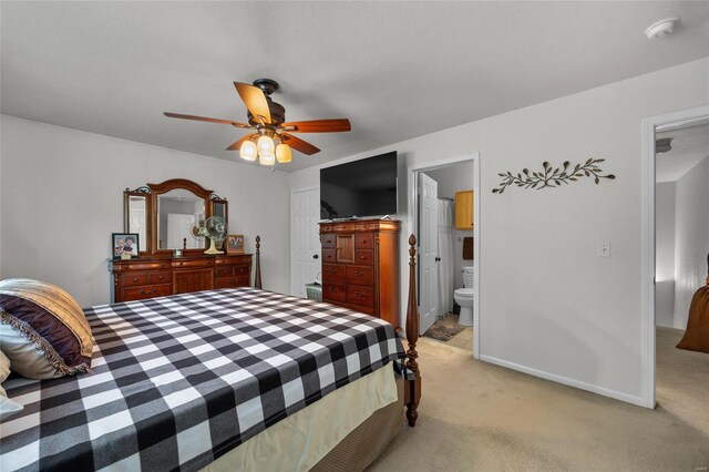 bedroom featuring ceiling fan, light colored carpet, baseboards, ensuite bathroom, and a closet