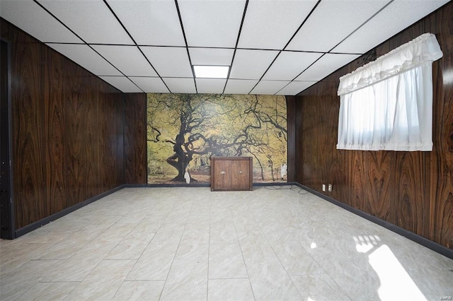 empty room with wooden walls and a drop ceiling
