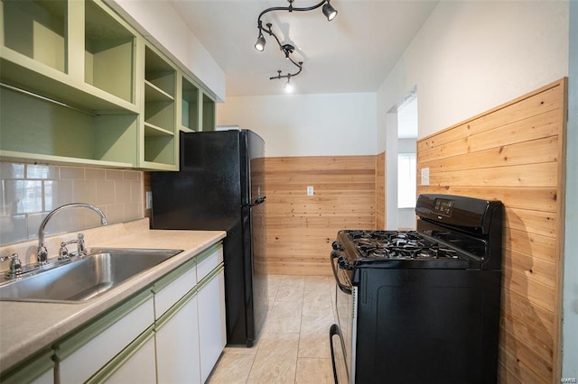 kitchen featuring freestanding refrigerator, tasteful backsplash, a sink, gas stove, and green cabinets