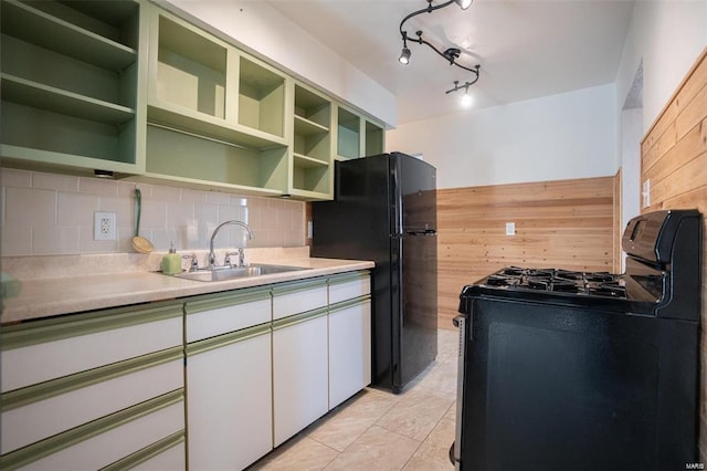 kitchen featuring open shelves, decorative backsplash, a sink, black appliances, and green cabinets