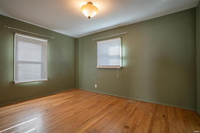 spare room featuring baseboards and wood finished floors