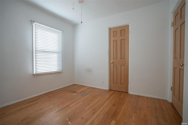 unfurnished room featuring a healthy amount of sunlight, baseboards, and light wood-style floors