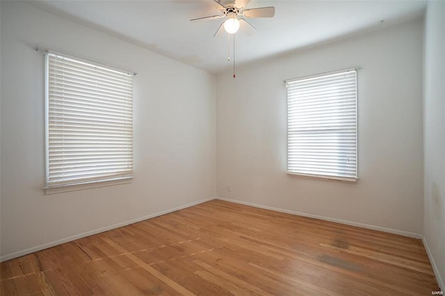 spare room featuring baseboards, light wood finished floors, and ceiling fan