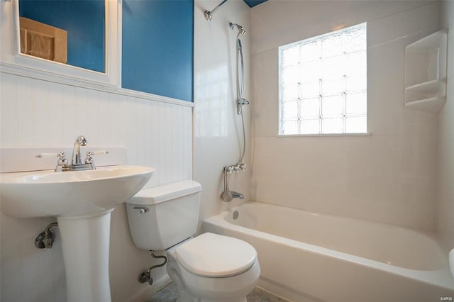 bathroom with toilet, shower / bath combination, and a sink